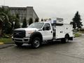 A 2015 Ford F-550 white utility truck with a custom service body and equipment mounted in the bed