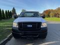 A 2008 Ford F-150 XL in white with a black grille parked on a driveway facing forward with visible headlights and front bumper