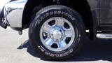 A close-up of a chrome rim with a Bridgestone Dueler H/T tire mounted on a 2014 RAM 3500 showcasing its polished wheel and treads