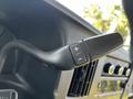 Close-up of the gear shift lever in a 2015 Chevrolet Express featuring buttons for gear selection marked with plus and minus symbols