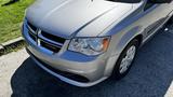 A silver 2016 Dodge Grand Caravan with a sleek design featuring a prominent front grille and headlights