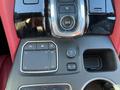 A close-up of the center console of a 2023 Acura MDX featuring a touchpad a dial for drive settings and audio control buttons