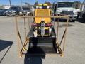 A 2024 AGT KTT23 Mini Skid Steer with a yellow frame and black bucket in front view displaying controls and tracks