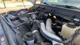 Engine compartment of a 2011 Ford F-450 SD showing various components like hoses and fluid reservoirs