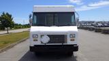 A white 2011 Ford Econoline food truck with a flat front and large windows is parked on a pavement area