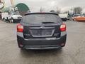 A black 2014 Subaru Impreza hatchback viewed from the rear with a clean design and distinctive taillights