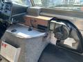 Interior view of a 2007 Ford Econoline showing the dashboard with controls and a grey felt storage compartment