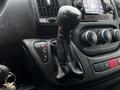 The gear shift of a 2018 RAM Promaster with a leather cover and nearby controls for towing and temperature adjustment