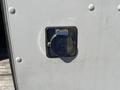 Close-up of the fuel filler cap of a 2011 Ford Econoline vehicle with a metal cover and a rectangular mounting frame