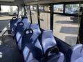 The interior of a 2017 Chevrolet Express van showing rows of blue upholstered seats without seat belts