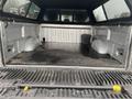 A 2014 Ford F-150 truck bed with a black rubber mat showing no cargo and two wheel wells on either side