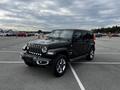 A black 2019 Jeep Wrangler with a distinctive seven-slot grille and round headlights parked in a lot