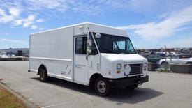 A 2011 Ford Econoline delivery truck with a white exterior and a front grille featuring a circular emblem