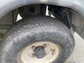 Close-up of a used tire from a 2000 Ez-go Industrial 800 featuring a black tread and a white rim with the words SPORT TRAIL visible on the sidewall