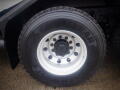 Close-up of a GoodYear tire mounted on a white rim showing eight lug nuts and the tread pattern on the tire