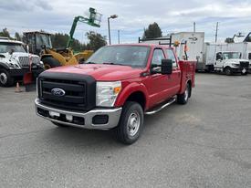 A red 2011 Ford F-250 SD pickup truck with a black front grille and dual rear wheels parked in a lot