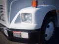 A 2006 Freightliner FS65 with a white exterior featuring a front light and a warning label stating danger electrical hazard keep clear