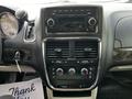 Interior dashboard of a 2011 Dodge Grand Caravan featuring a central control panel with buttons and knobs for the audio and climate systems