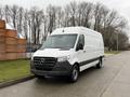 A 2019 Mercedes-Benz Sprinter van with a white exterior and black accents parked on a street