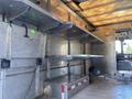 Interior view of a 2008 Ford Econoline van with metal shelving and a metal storage area