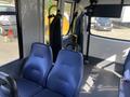 Interior of a 2017 Chevrolet Express showing two blue upholstered seats with armrests and a partition behind them