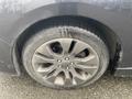 A close-up of the tire and alloy wheel of a 2014 Subaru Impreza with a wet surface and visible tread pattern