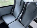 Two grey upholstered seats with seat belts in a vehicle interior