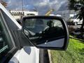 Side mirror of a 2017 GMC Sierra 1500 reflecting a cloudy sky and the interior of the truck