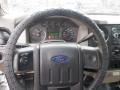 The interior of a 2009 Ford F-450 SD featuring a steering wheel with a textured cover and a dashboard displaying gauges and controls