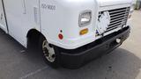 A white 2011 Ford Econoline with a black bumper and missing front grille features a flat front design with round headlights and a side panel marked ISO 9001