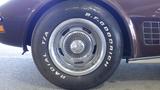 A close-up of the wheel and tire of a 1971 Chevrolet Corvette Stingray featuring a chrome hubcap and lettering on the tire sidewall