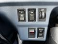 Dashboard controls of a 2006 Hino 268 featuring buttons for setting cruise control, an on/off switch, and a dimmer for dashboard lights