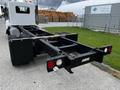 A 2014 Kenworth T370 truck chassis with visible rear axles and dual tires showcasing a minimalist design without a cargo container