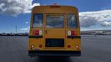 Rear view of a yellow 2014 Freightliner Thomas diesel bus featuring large windows and an emergency door sign