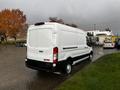 A white 2020 Ford Transit van with black accents parked on a wet surface