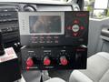 A control panel with various buttons and a digital display designed for operating equipment in a 2012 Ford F-550