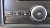 Close-up of the audio control panel in a 2012 GMC Savana featuring buttons for band and seek functions along with a power knob